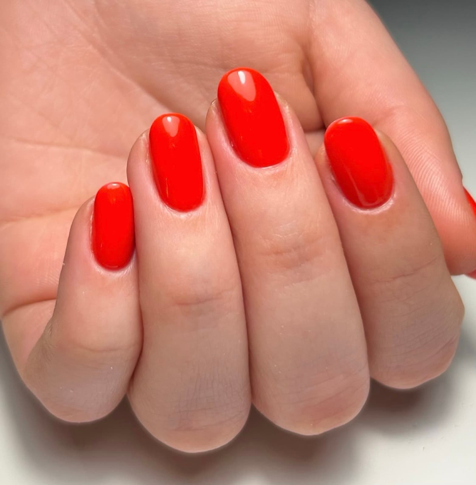 Gainage rouge sur ongles courts arrondis, réalisé chez GLOWEE
